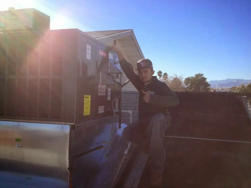 HVAC technician performing AC Tune-Up on a rooftop unit in Globe